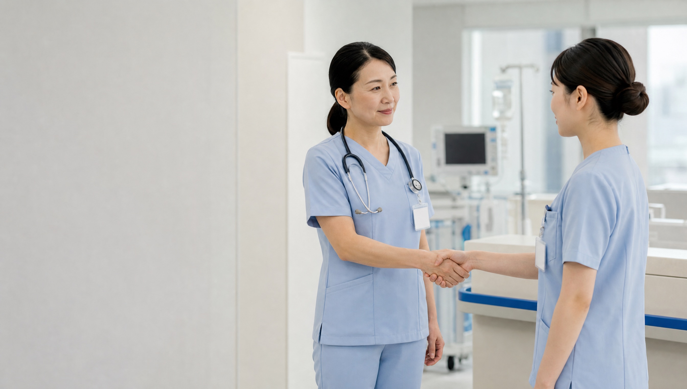 入職してきた看護師を握手で迎える先輩看護師
