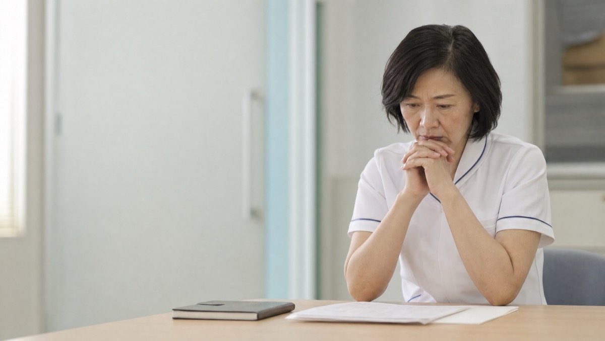 ナースステーション付近で静かに電話する看護部長らしき人物